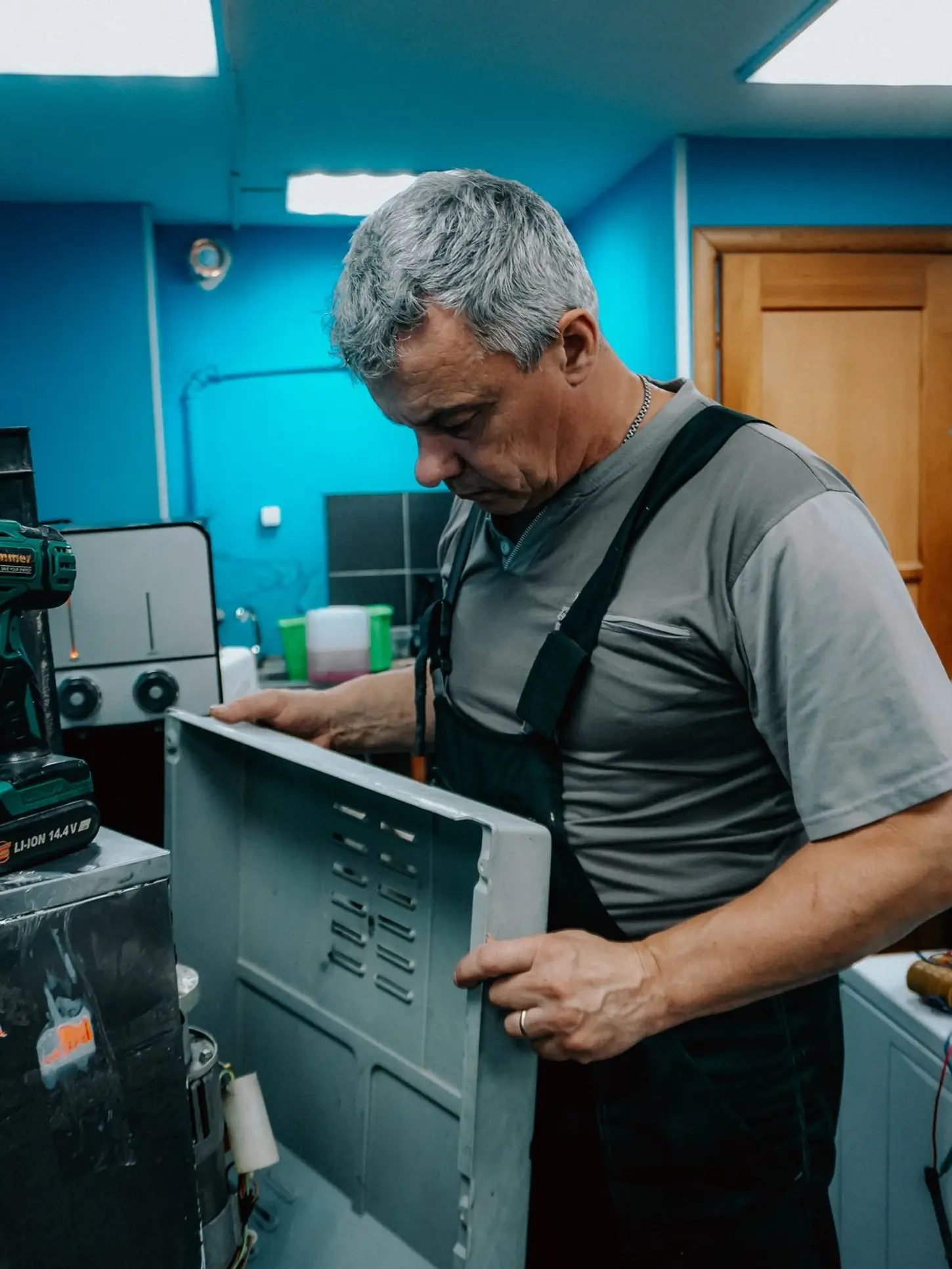 Washing machine repair technician diagnosing a front-load washer in Portland, OR